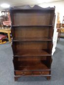 A set of mahogany open shelves fitted with drawers
