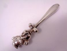 A white metal baby's rattle.