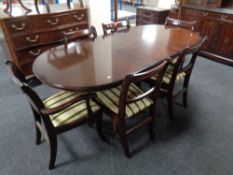 A Regency style inlaid mahogany twin pedestal table with leaf and six chairs