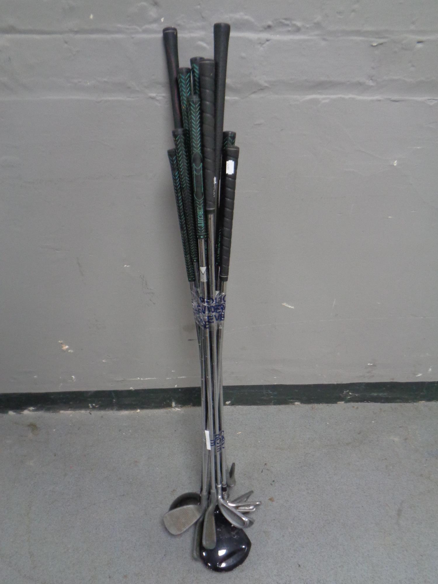 A bundle of assorted golfing irons and drivers