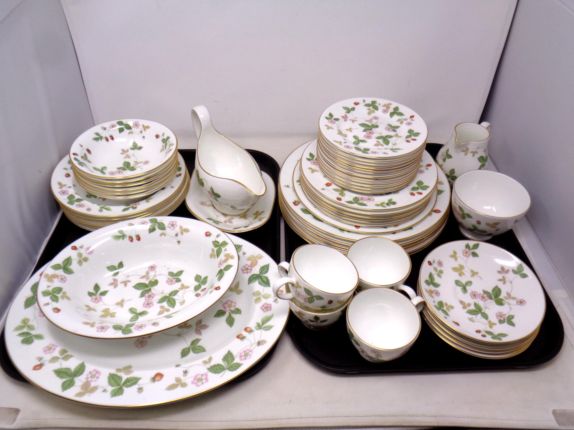 A large quantity of Wedgwood wild strawberry gilded china and dinner plates