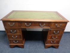 A Victorian style mahogany nine drawer twin pedestal writing desk with leather top