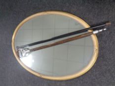 An Edwardian gilt framed oval mirror together with a walking cane,