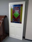 A painted Edwardian interior door with multi coloured leaded glass inset panel