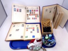 A tray of chess pieces, stamp albums,