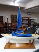 A plastic pond yacht with blue sail