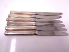 Six cake knives with silver handles.
