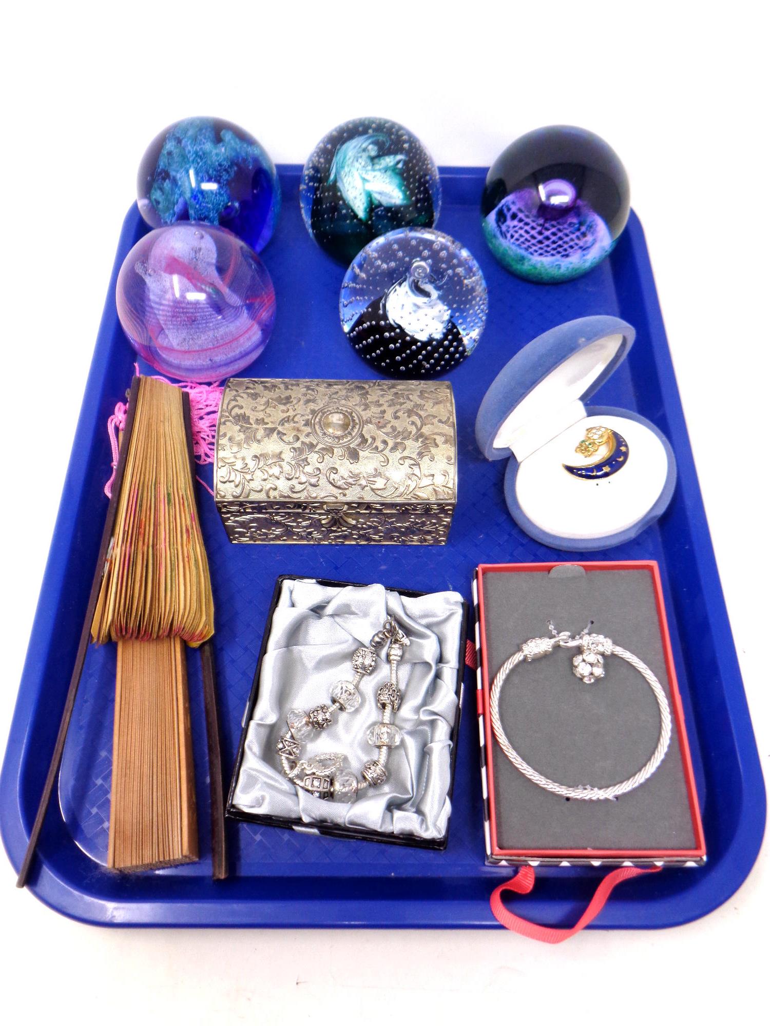 A tray of glass paperweights, costume jewellery,