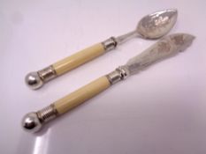 A silver plated knife and spoon with ivory effect handles.