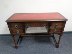 An Old Charm five drawer desk with red leather top
