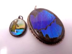 Two silver butterfly wing pendants.