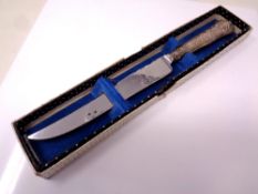 A silver handled cake knife in retail box.