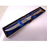 A silver handled cake knife in retail box.