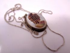 A silver pendant on chain.
