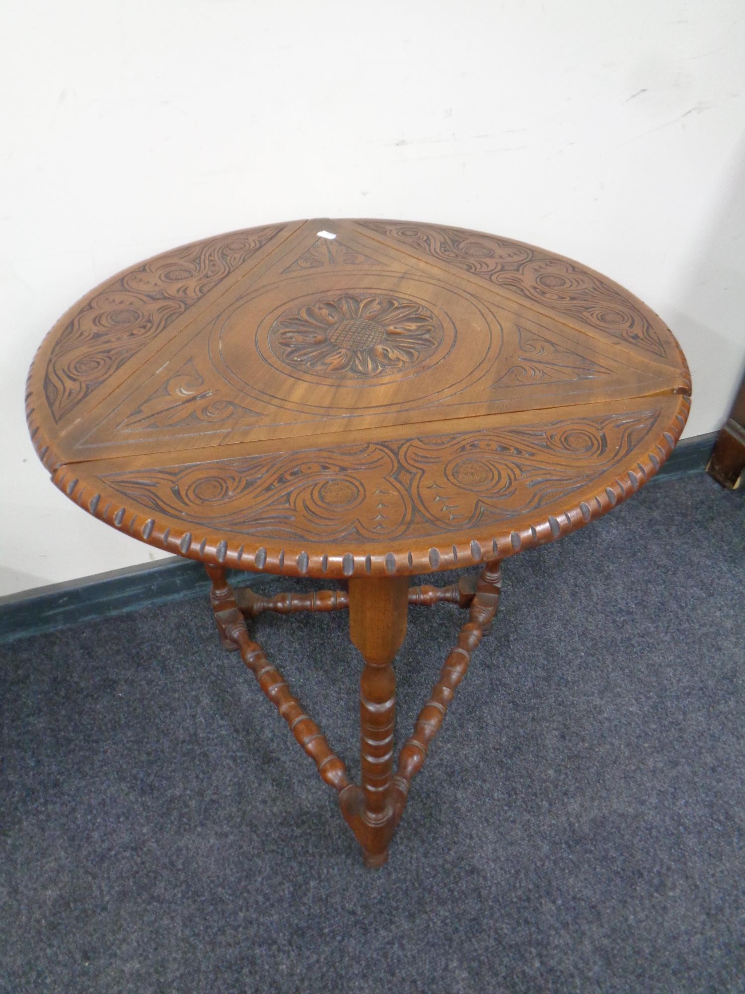 An Edwardian carved beechwood flap sided occasional table