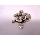 A silver dragon pendant.