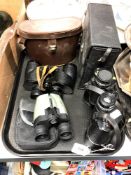 A tray of binoculars and optical items,