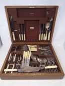 An Edwardian oak canteen of silver plated and stainless steel cutlery.