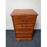 A yew wood narrow five drawer chest.