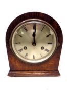 A 20th century dome topped oak cased mantel clock with silvered dial,