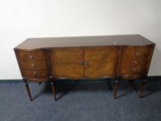 A Regency style mahogany sideboard fitted six drawers and two central doors on raised legs