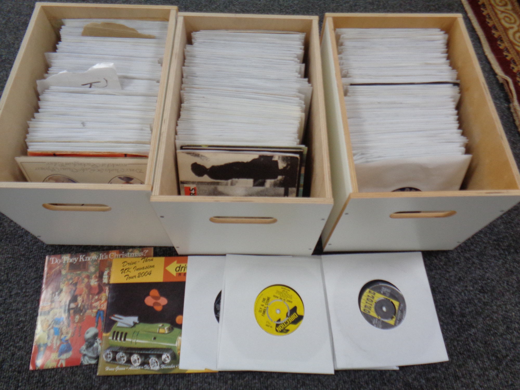 Three wooden boxes containing vinyl 7" singles, 1950's onwards.