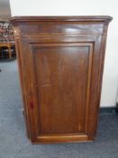 A George III oak panelled door corner cupboard