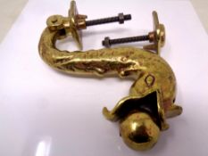 An ornate brass fish door knocker.