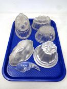 A tray of three antique glass jelly moulds together with two further metal moulds and a glass