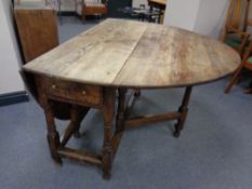 A 19th century oak gate leg table fitted a drawer