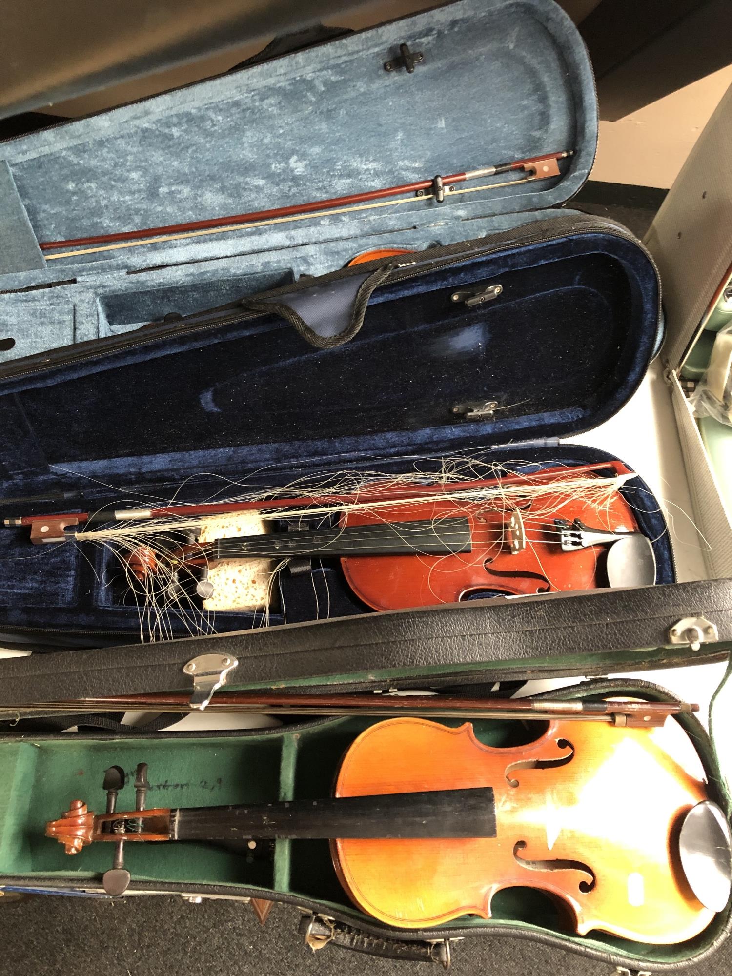 Three student violins in cases