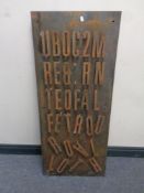 A collection of metal letters mounted on a steel plate