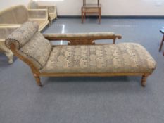 A late 19th century carved oak chaise longue upholstered in a tapestry fabric