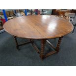 A heavy oak drop leaf farmhouse kitchen table on bobbin legs