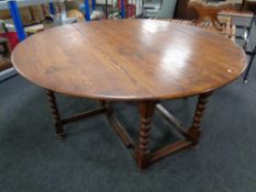 A heavy oak drop leaf farmhouse kitchen table on bobbin legs