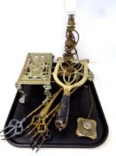 A tray containing antique and later brass ware to include trivets, toasting forks,