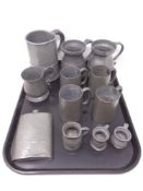 A tray of antique pewter, tankards and measuring jugs,