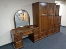 A four piece carved oak bedroom suite comprising of double door wardrobe,