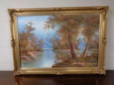 A decorative gilt framed oil on canvas, river through a wooded landscape.