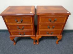 A pair of yew wood three drawer bedside chests on cabriole legs