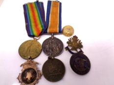 A tobacco tin containing a pair of WWI medals comprising British War Medal and Victory Medal on