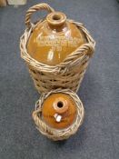 Two antique stoneware flagons in wicker baskets by A H Higginbottom and Company,