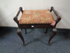 An Edwardian storage piano stool on cabriole legs