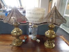 A pair of brass Moroccan style table lamps together with a further contemporary brass and cut glass