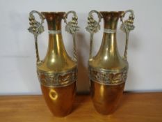 A pair of embossed brass twin handled vases, height 31 cm.