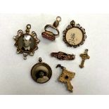 A collection of antique pendants, fob, yellow metal crucifix, antique bar brooch,