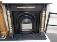 A Victorian style cast iron fire insert with painted surround and black marble hearth.