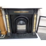 A Victorian style cast iron fire insert with painted surround and black marble hearth.