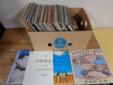 A crate containing a quantity of vinyl LPs and 12" singles to include Madonna, Elton John,