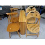 A narrow pine drop leaf kitchen table together with a pair of folding chairs and a further pair of